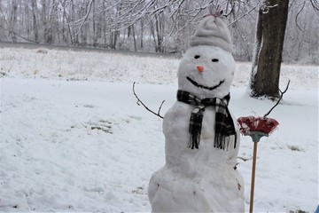 Smiling snowman holding broom