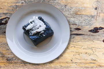 Thai dessert Rhombic in white ceramic dish on wooden floor.