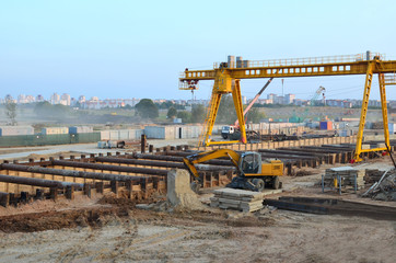 Excavator working at construction of a new metro line. Contractor digding the tunnel subway and railway station platform deep underground. Piles driven into the ground by hydraulic hammering.
