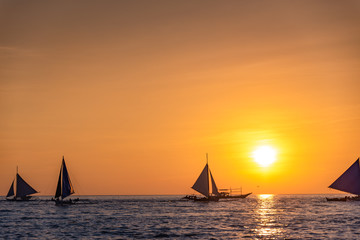 Fototapeta na wymiar Paraw sailing at Boracay Island, Philippines at Sunset