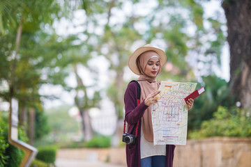 Portrait of beautiful young solo Muslim traveler exploring the city