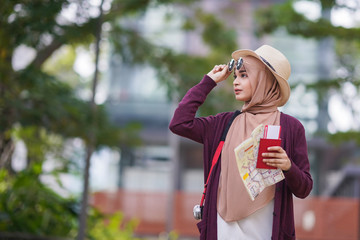 Portrait of beautiful young solo Muslim traveler exploring the city
