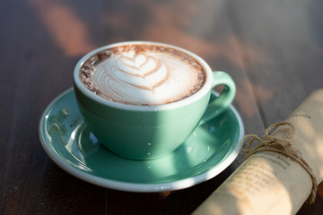 One coffee cup of hot black cappuccino on clean wooden table top view in warm morning light. Hot espresso in ceramics mug on empty rustic brown wood color concept for Aroma love caffeine taste smell.