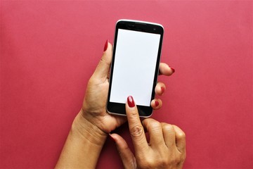 Women hands using smartphone photo isolate on pink background copy space 