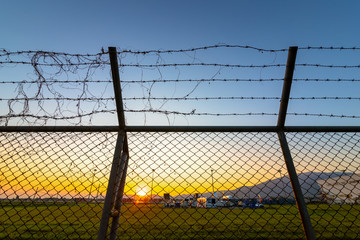 Airport security fence at  sunset.