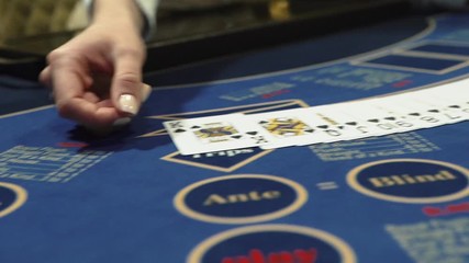 Dealer beautifully lays out cards on the card table in the casino - Powered by Adobe