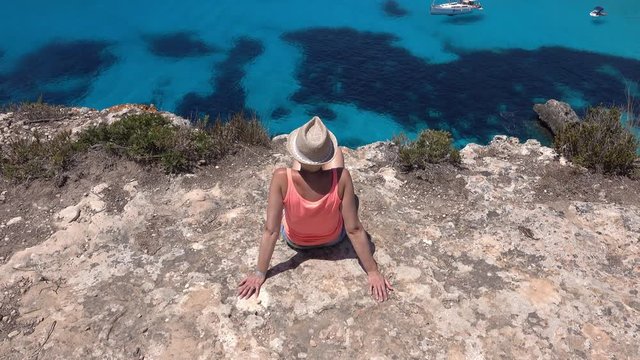 Une femme se reposant en haut d'une falaise &agrave; Minorque