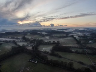 An aerial view of fields and the hedges on a misty evening