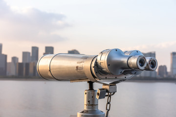 telescope with city skyline