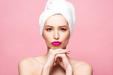 sad naked woman in white towel looking at camera isolated on pink