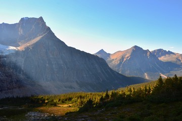 Panorama of Mount Edith Cavell. High mountains with glacier, sun rays illuminate the forest. Sunny...