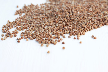 scattered buckwheat, small dark grain, grain for feeding animals, groats for making flour, healthy food, slow carbohydrates, white table