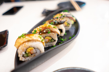 Japanese food mackerel sushi roll On a black plate .Focus on the second piece