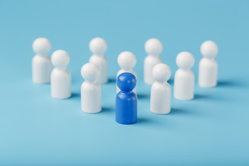 Obraz premium The leader in blue leads a group of white employees to victory, HR, Staff recruitment. The concept of leadership.