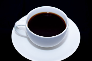 White cup of coffee on black background