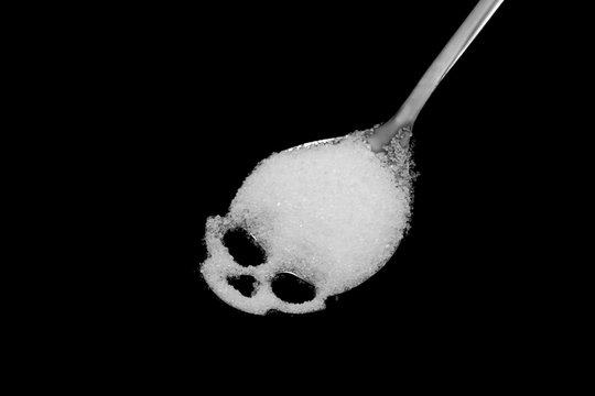 White sugar in skull shape spoon, concept idea is risk of Diabetes mellitus