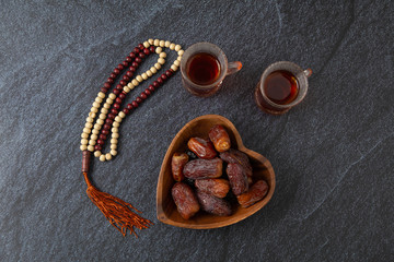 food Ramadan Sweets mixed of dried fruits and nuts Glass Tea with  rosary and the Quran on the...