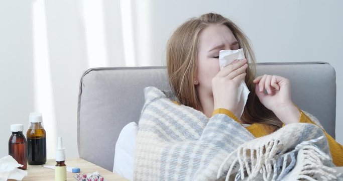 Young woman suffering from cold at home