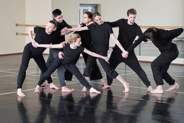 Photo sur Aluminium École de danse Group of professional contemporary dancers wearing black clothes having rehearsal in studio, horizontal shot