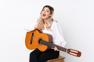 Fototapeta premium Teenager girl with guitar over isolated white background with surprise facial expression