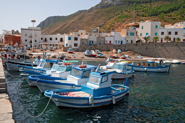Fototapeta na wymiar Some fishing boats anchored on the shore in the small port of the island of Marettimo, in the Egadi islands in Sicily, Italy.