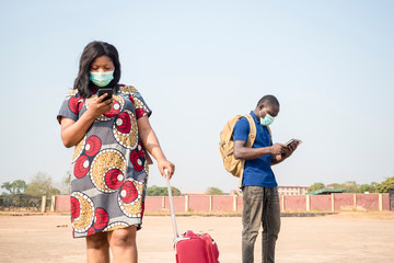 black people, travelers, wearing face masks, standing outdoors