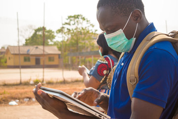 black people, travelers, wearing face masks, standing outdoors © Confidence