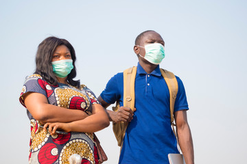 black people, travelers, wearing face masks, standing outdoors