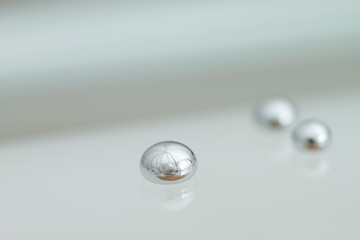 Shiny Mercury drops over a glass surface