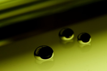 Shiny Mercury drops over a glass surface