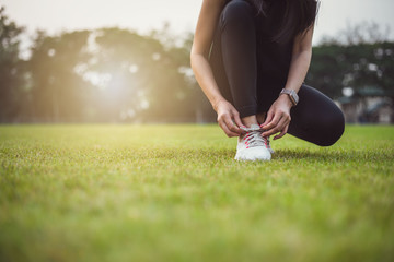 Women warm up before exercising outdoors during the morning hours in the park.