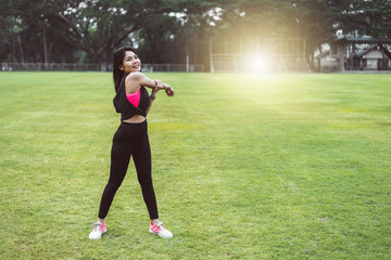 Women warm up before exercising outdoors during the morning hours in the park.