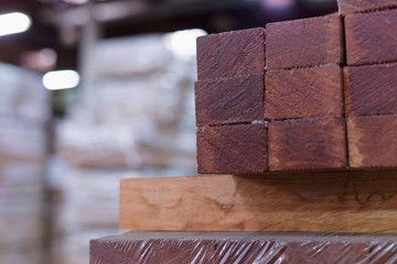 Timber Flooring Factory. Pile of cut wood in factory storage warehouse. Lumber in warehouse.