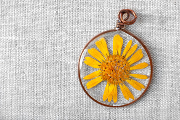handmade epoxy resin jewelry. pendant. calendula officinalis flower in copper frame