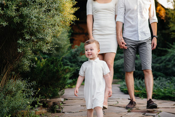 Fototapeta premium Happy family with their son walking in the Park at sunset. Happiness. Love