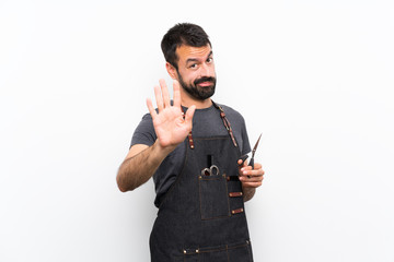Barber man in an apron making stop gesture