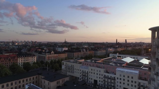 Aerial view of Stockholm cityscape skyline and high-rise building at sunset. Drone shot flying backwards next to skyscraper tower building, G&auml;rdet, &Ouml;stermalm. Beautiful sky, Capital city of Sweden