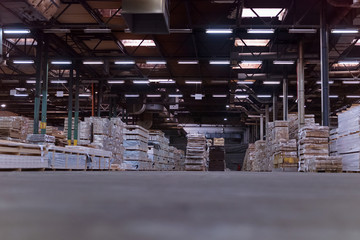 Timber Flooring Factory. Pile of cut wood in factory storage warehouse. Lumber in warehouse.