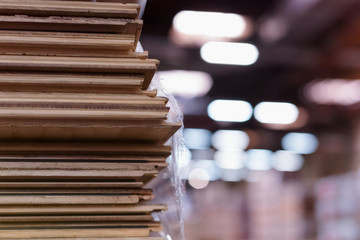 Timber Flooring Factory. Pile of cut wood in factory storage warehouse. Lumber in warehouse.