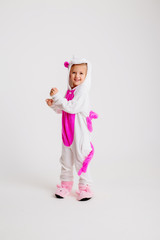 little blonde girl in kigurumi on white background, space for text.modern fashion -children girl posing on a white background in kigurumi pajamas, bunny costume