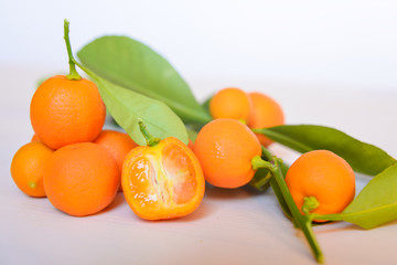 Calamondins on white cutting board