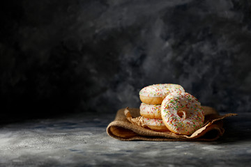 Fresh tasty donuts on dark mood background and free space for your decoration. 