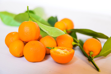 Calamondins on white cutting board