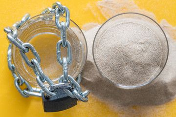 a glass of water braided and closed with a padlock, the second glass full of sand.  Global warming,...
