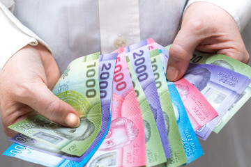 Chile pesos, banknotes in a woman's hand