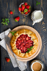 Baked galette or open strawberry pie on the table.
