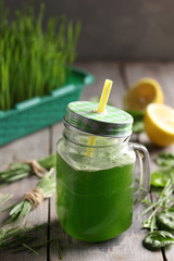 The concept of healthy cuisine. Wheatgrass  with orange on a dark background. Background image, copy space