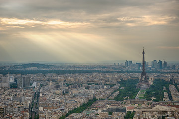 Aerial view of Paris, France. Eiffel tower in overcast sky with light rays.