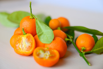 Calamondins on white cutting board