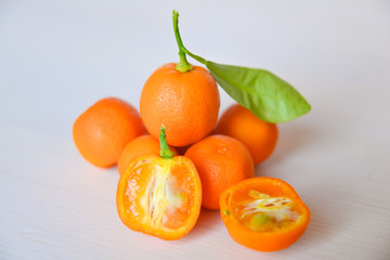 Calamondins on white cutting board